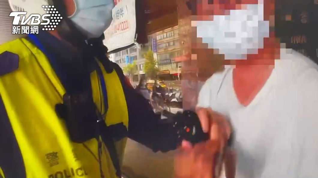 員警認為攤販情緒過於激動才將人壓制。(圖/TVBS)