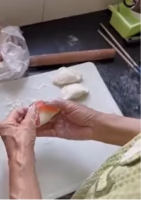 在假牙的輔助下，阿嬤10秒包好一顆。（圖／翻攝自爆笑公社）