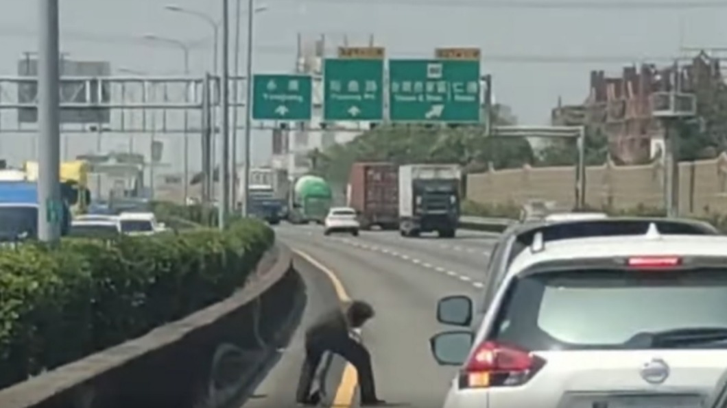 一名長髮男子下車幫忙撿拾。(圖/八卦村 - 行車紀錄器影片)上傳中心