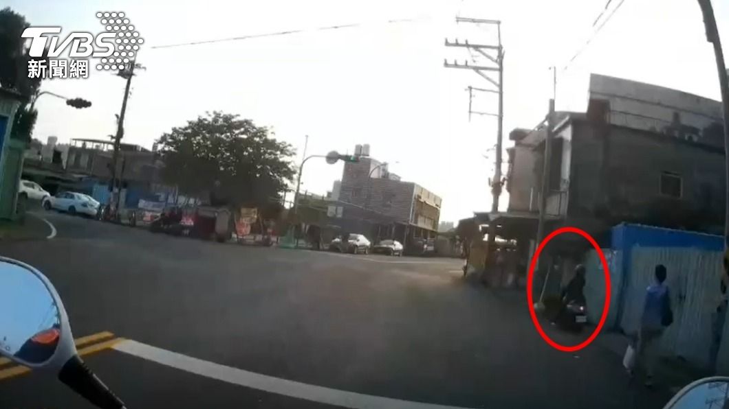 員警見一名騎士邊吃大腸包小腸邊騎車。（圖／TVBS）