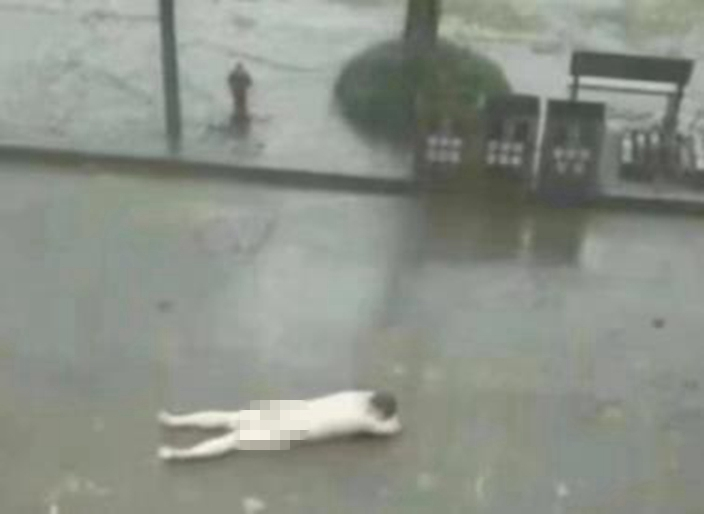 許多人拍下裸男趴地卻沒人上前幫忙。(圖/翻攝自《星洲網》)