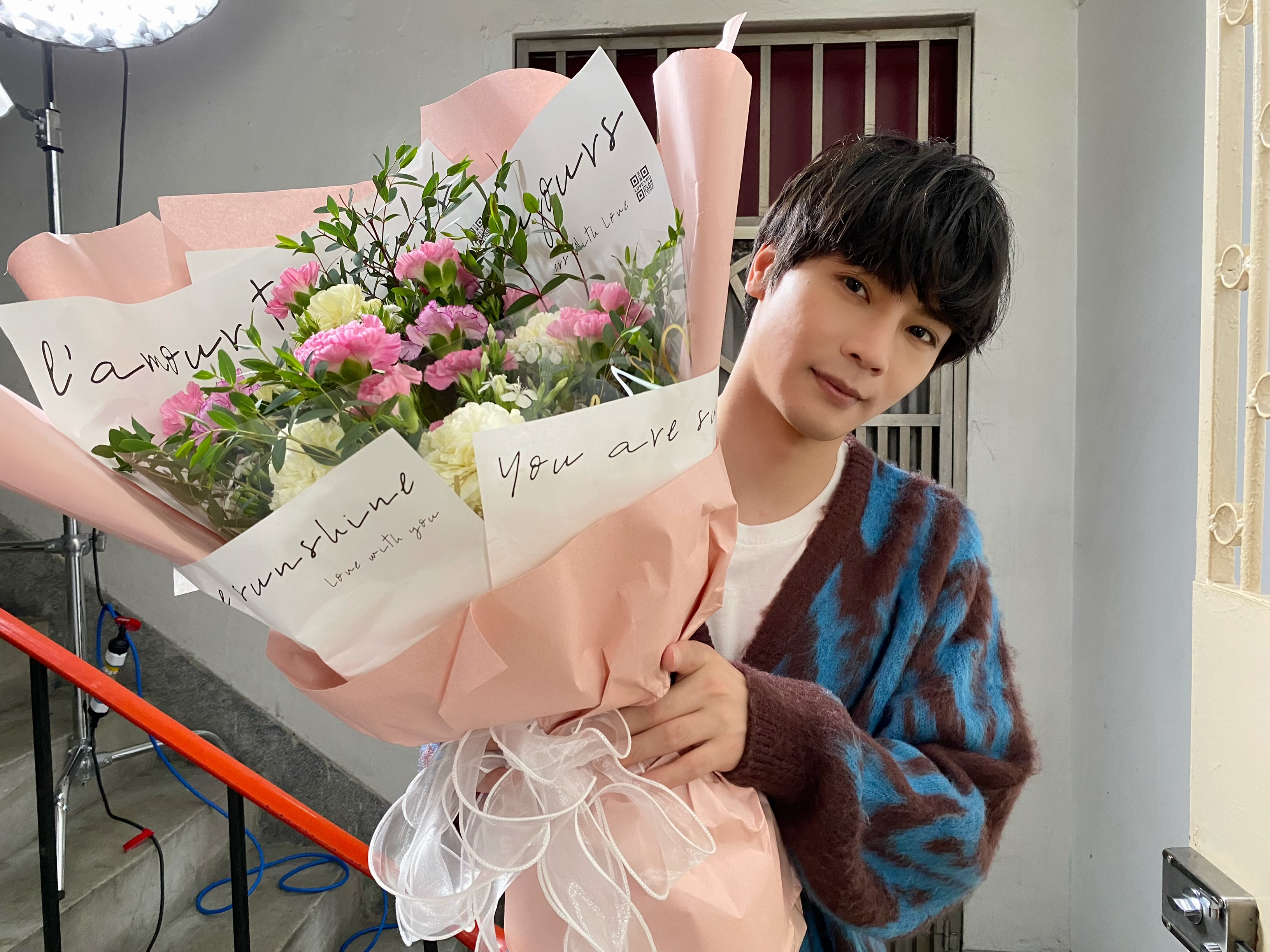 古曜威MV中，捧著康乃馨花束，給予媽媽滿滿的驚喜。（圖／單純夢想文創事業、華納音樂提供）