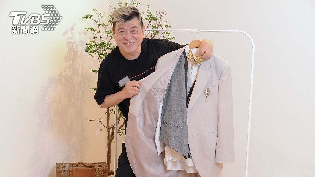 孫德榮拿著人生的最後一套西裝。（圖／許方正攝）