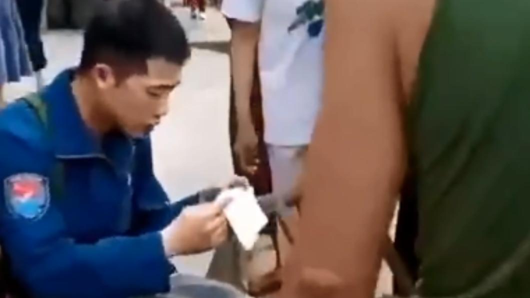 穿著藍色飛行衣的男子，疑為跳傘生還的機師。（圖／翻攝自微博）