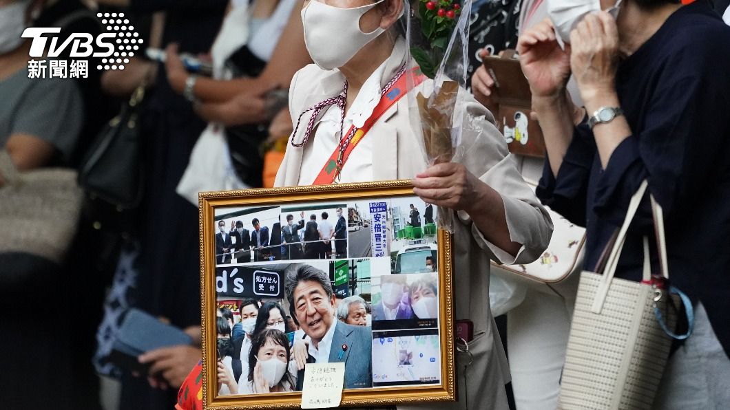 把與安倍合照做成相框紀念的民眾。(圖/歐新社達志影像)