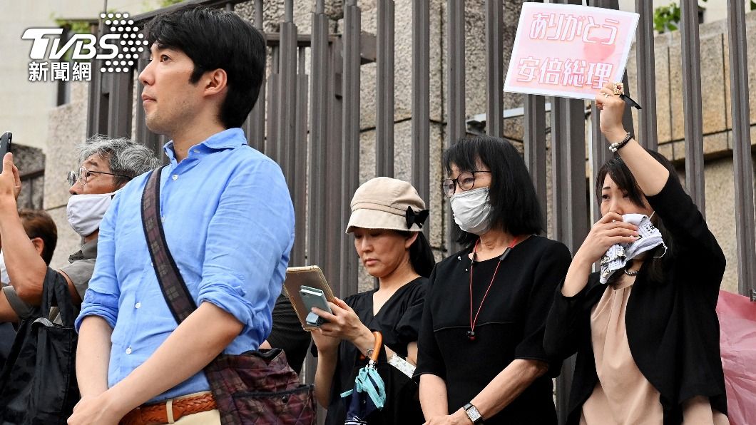 有人舉著「謝謝安倍」的標語。(圖/達志影像美聯社)