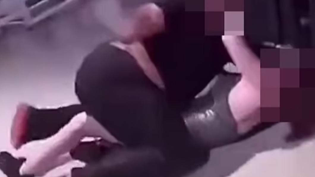 身穿黑色長褲女子將身穿連身短裙女子壓制在地猛打。(圖/翻攝自 每日星報)