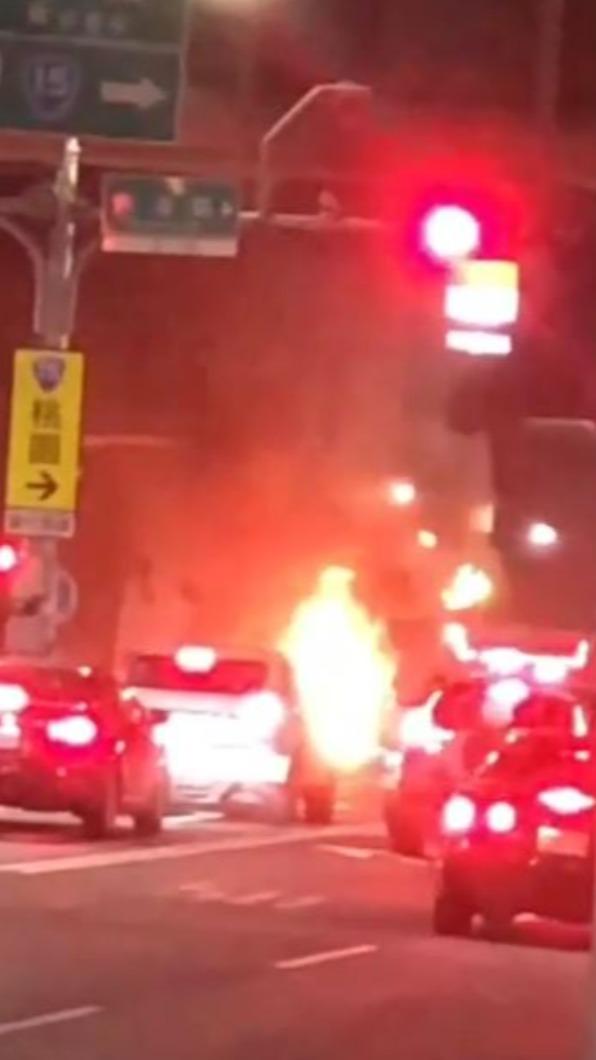 駕駛在路口停等紅綠燈,車頭位置突然竄煙起火。(圖/翻攝自爆料公社)