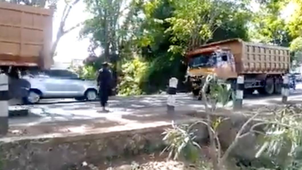 當時在路邊有多輛砂石車經過,他選定了最後一輛並且直接走到道路中間進行攔截。(圖/翻攝自twitter@ndagels)