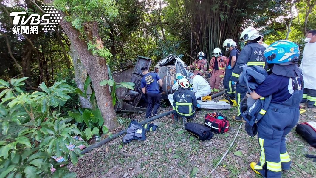 汽車衝破護欄摔下山，駕駛受困車內，大批消防人員到場搶救。（圖／TVBS）