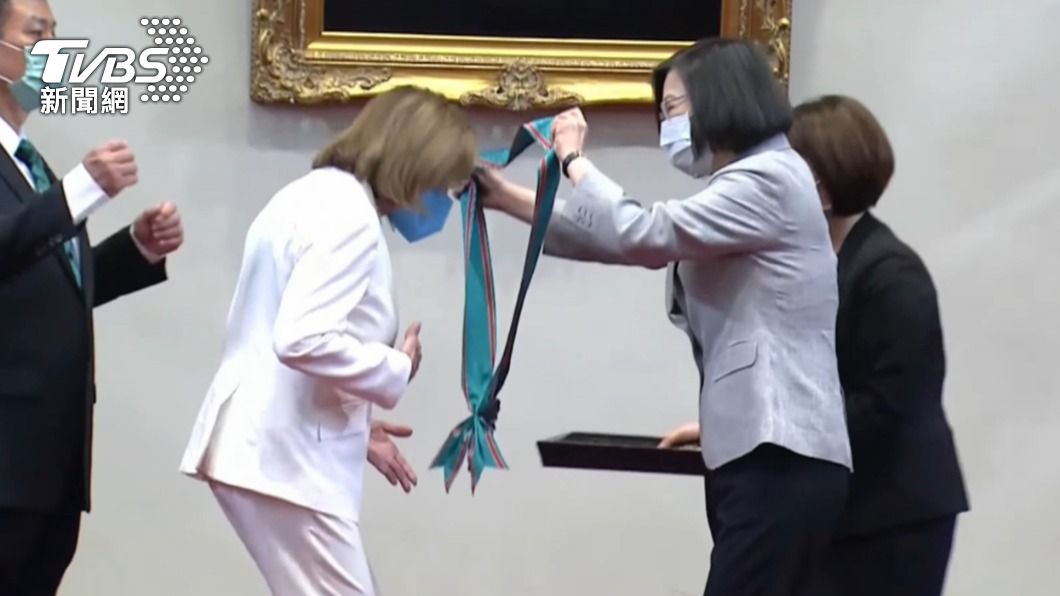 蔡英文細心地將背帶替裴洛西戴上。(圖/TVBS)