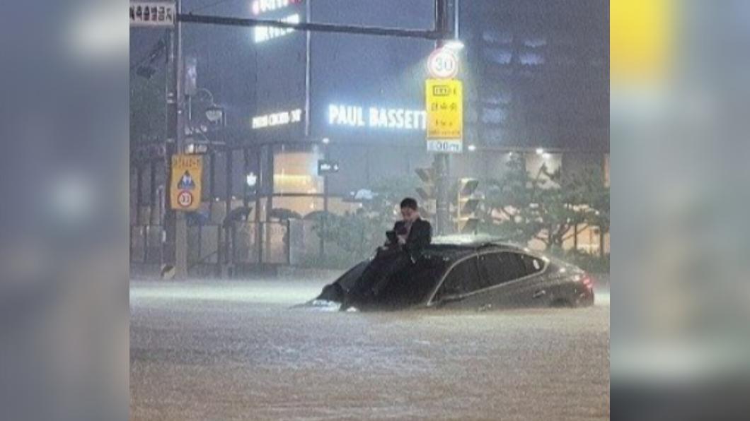 首爾豪雨成災!韓國大叔淹水困車頂 淡定滑手機意外爆紅