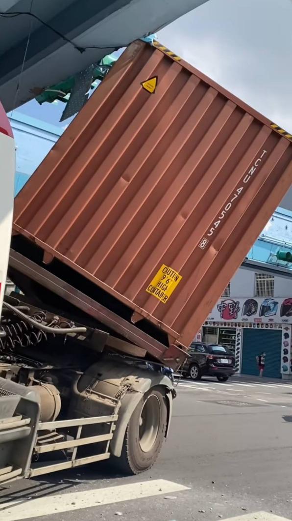 貨櫃車卡在天橋底部。(圖/翻攝自記者爆料網)