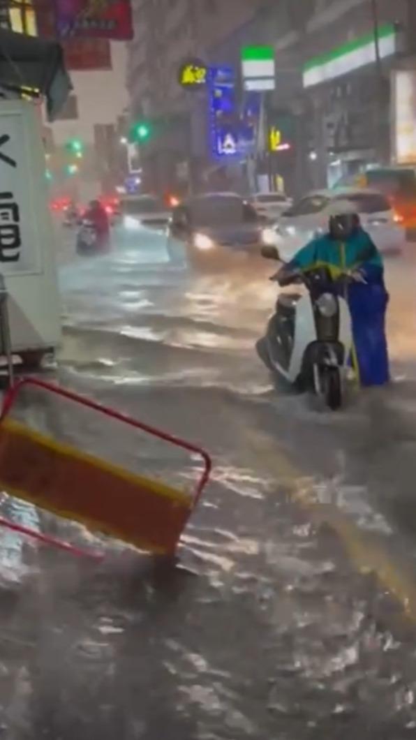 騎士無法騎車通行,只好涉水牽車。(圖/翻攝自記者爆料網)