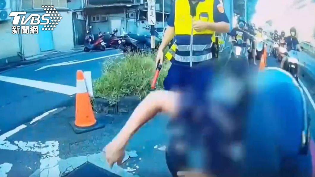 警員肉身擋車，江男重心不穩摔車。（圖／TVBS）