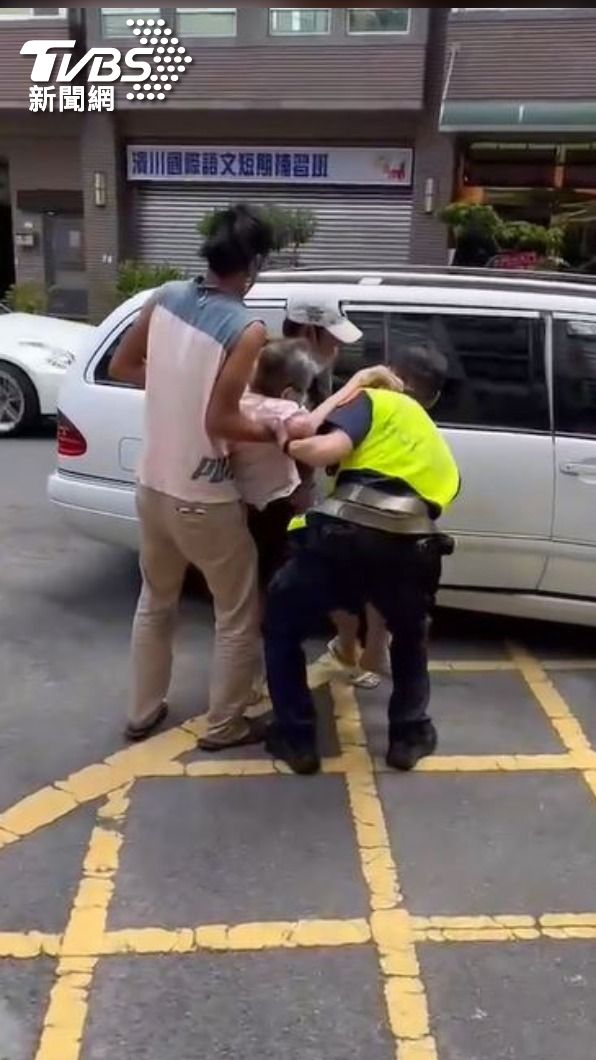 兩名熱心民眾和員警合力將阿嬤抱上轎車。(圖/TVBS)