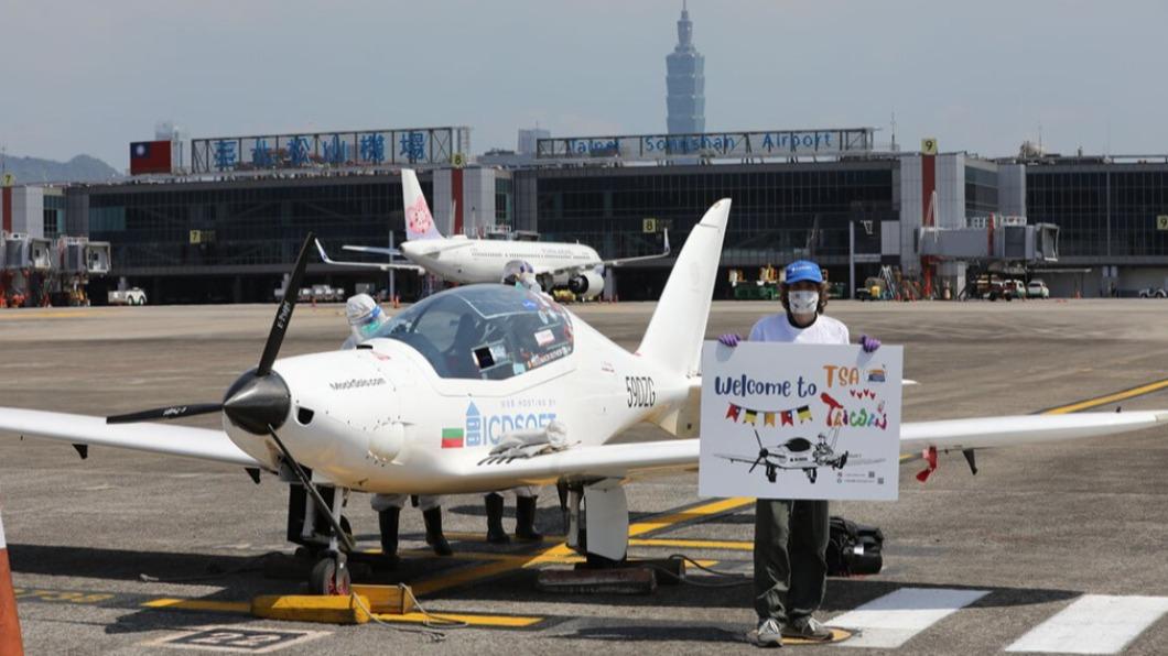 麥克在7月22日降落台北松山機場,拿著機場人員贈送的看板拍照留念。(圖/翻攝自Focus Taiwan)