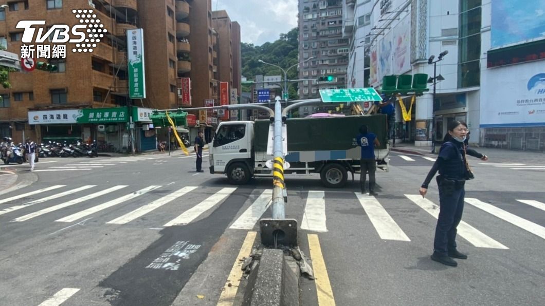 轉不過還硬轉！拖板車附載挖土機「超長」　撞倒號誌燈桿