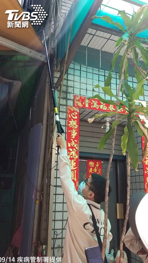 防疫人員於高雄市前鎮區執行孳生源查核,運用磯玉柄協助民眾檢視家戶外遮雨棚是否有積水產生孑孓或蚊卵 (圖/疾病管制署提供)