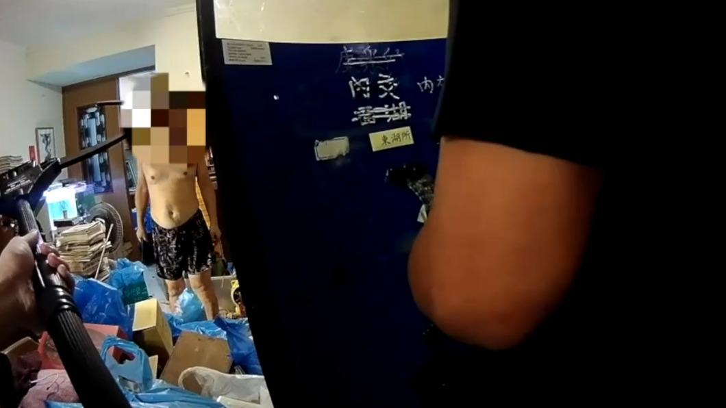 警方持新型裝備「伸縮抓捕器」面對持刀男子。(圖/TVBS)