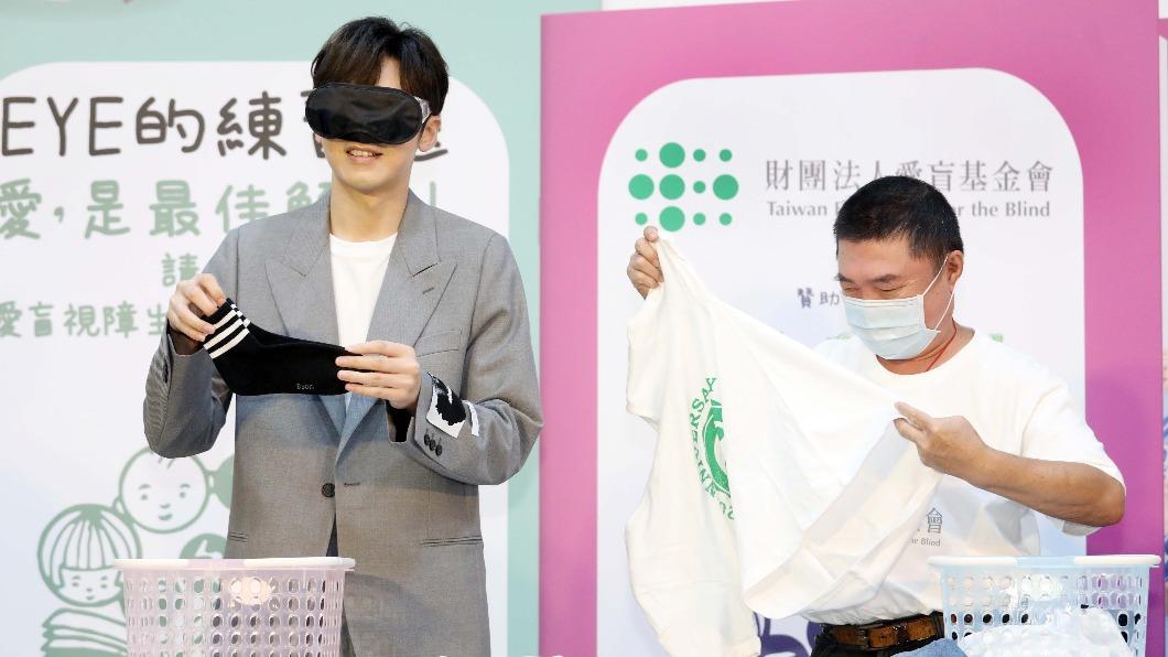 李國毅(左)曚眼與視障爸爸挑戰摺衣服。(圖/愛盲基金會提供)