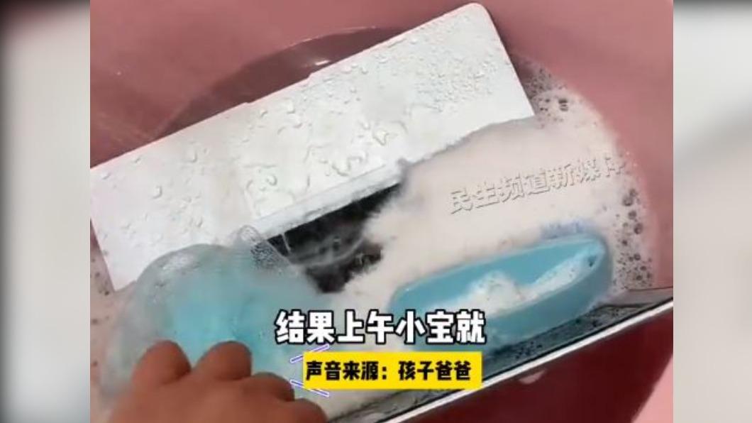 女兒貼心地把父親的筆電放入水中清洗。(圖/翻攝自微博)