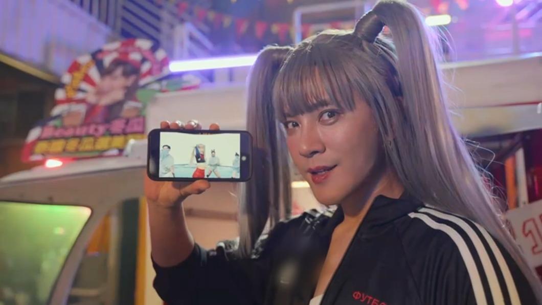 羅志祥拿起手機,裡面播放Lisa的MV。(圖/華納音樂提供)