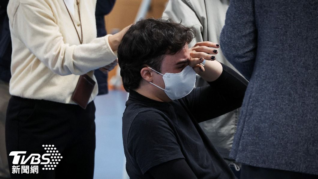 一名男子在名單上找尋朋友時哭了出來。(圖/達志影像路透社)