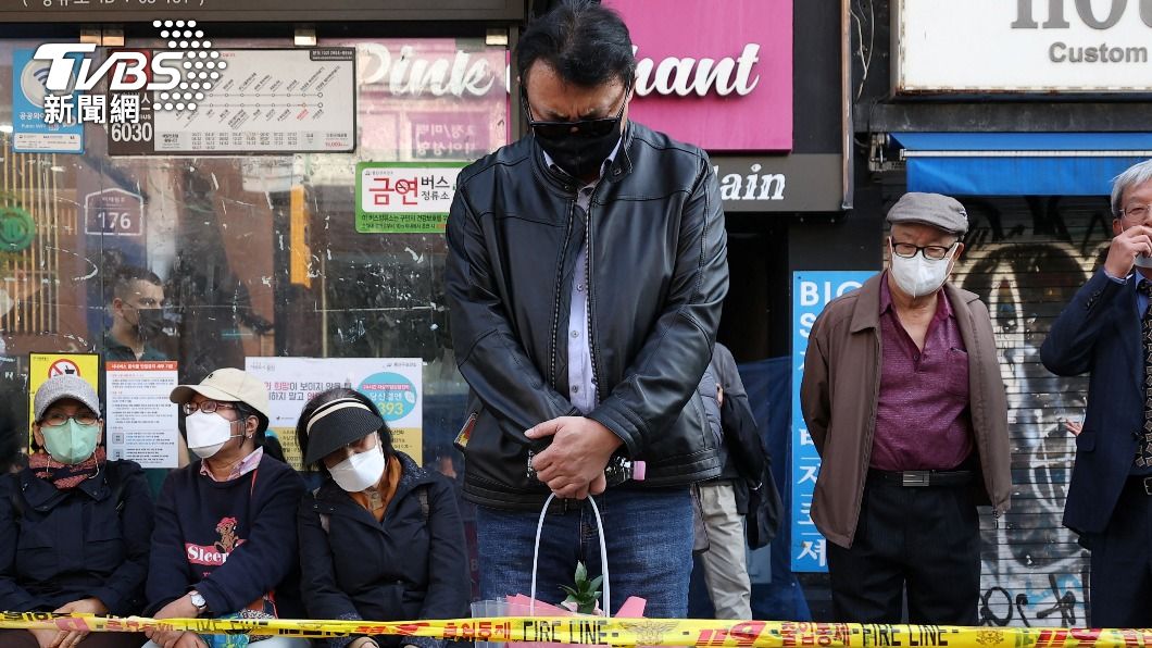 民眾聽聞噩耗後，在現場附近的封鎖線外低頭哀悼傷亡者。（圖／達志影像路透社）