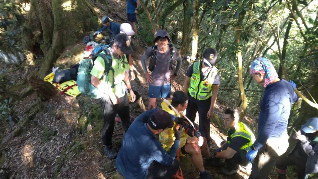 鄭姓男子疑似拉到斷裂的引導繩摔落邊坡,警消協助救援包紮。(圖/TVBS)
