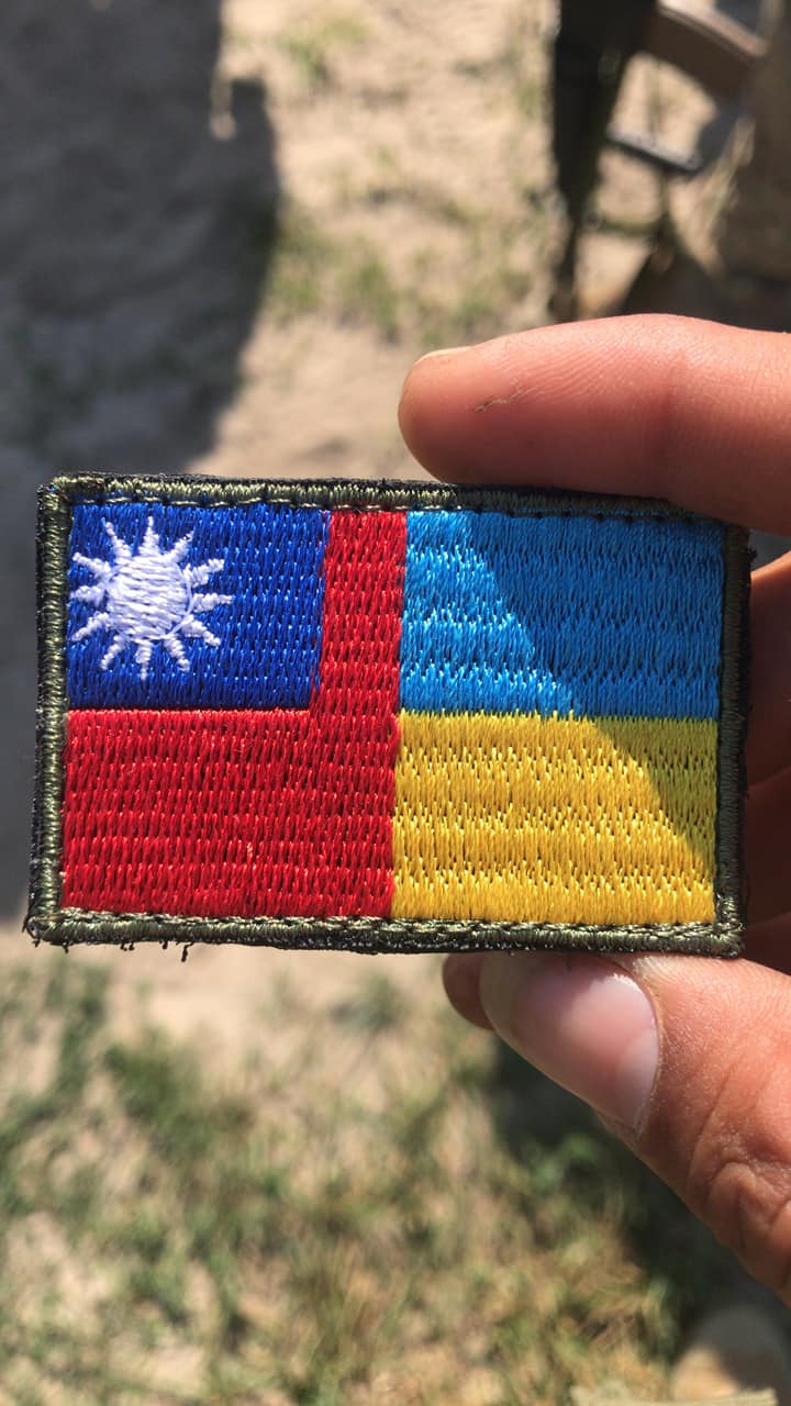 曾聖光戴著中活民國、烏克蘭國旗合併的物品。(圖/翻攝自當事人臉書)