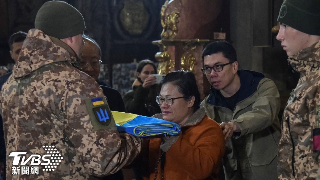 曾聖光母親代替其子領取軍方授予的烏國國旗及獎章。(圖/達志影像路透)