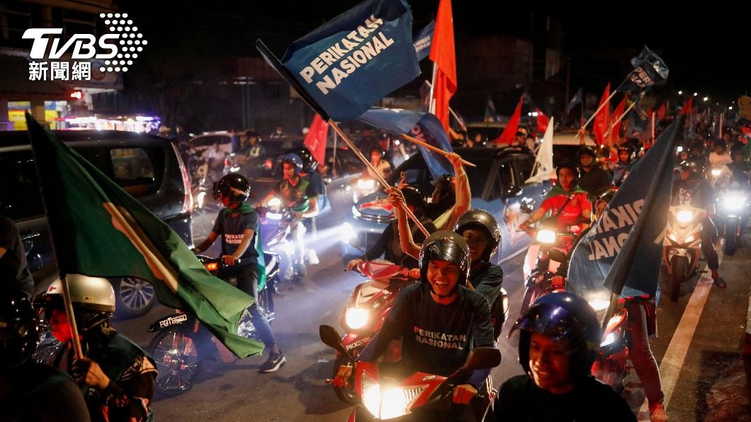 馬國民眾於選舉夜時揮舞著支持政黨的旗幟,騎車上街造勢。(圖/達志影像路透)