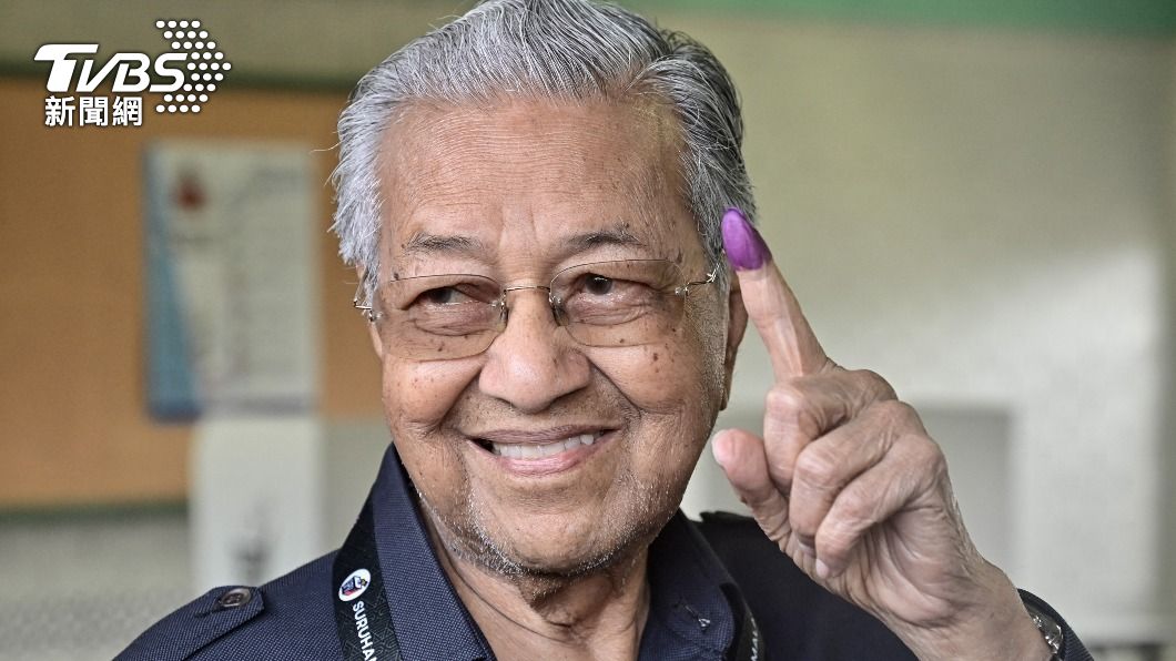 前首相馬哈地在投票完之後,向媒體秀出手指上的印泥。(圖/達志影像路透)