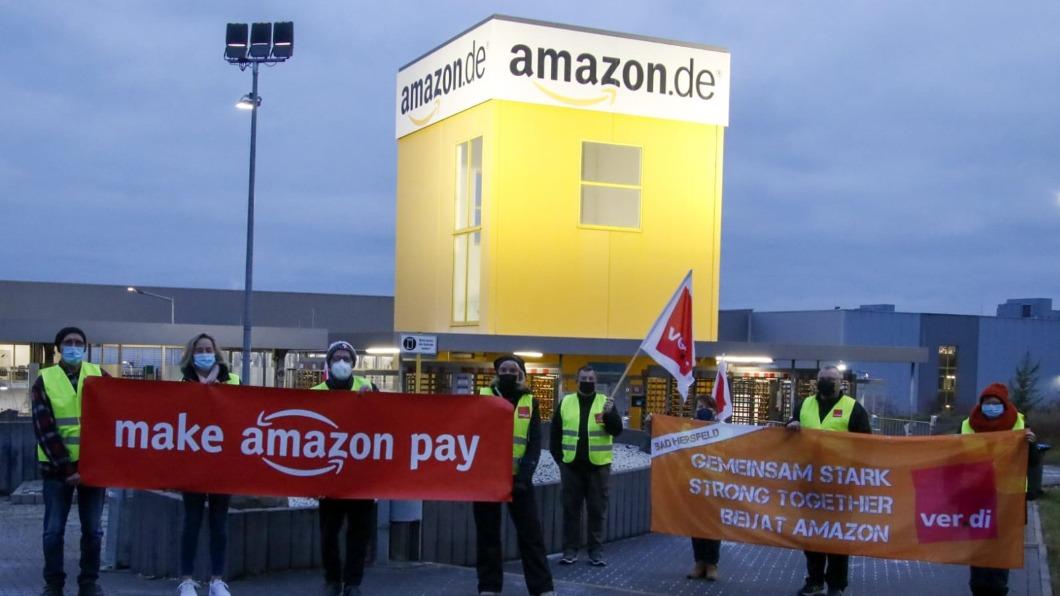 員工們舉起「Make Amazon Pay」的布條橫幅,訴求公司提高勞工待遇。(圖/翻攝自推特)
