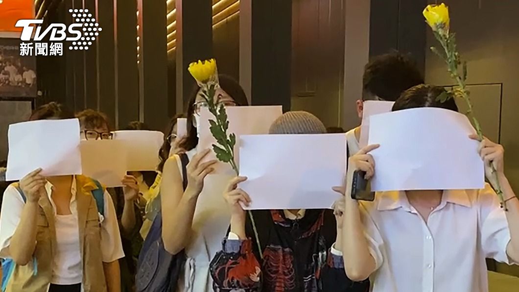 白紙革命也延燒到香港,民眾舉起鮮花與白紙和平抗議。(圖/達志影像美聯)