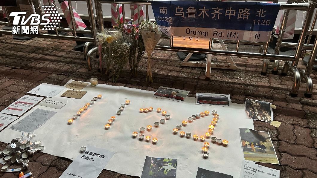 香港民眾用蠟燭排出烏魯木齊大火的日期11.24,並放上烏魯木齊中路的路牌表達抗議。此前,上海「烏魯木齊中路」因示威者不斷聚集於此,而被網友拍到路牌遭拆。(圖/達志影像美聯)