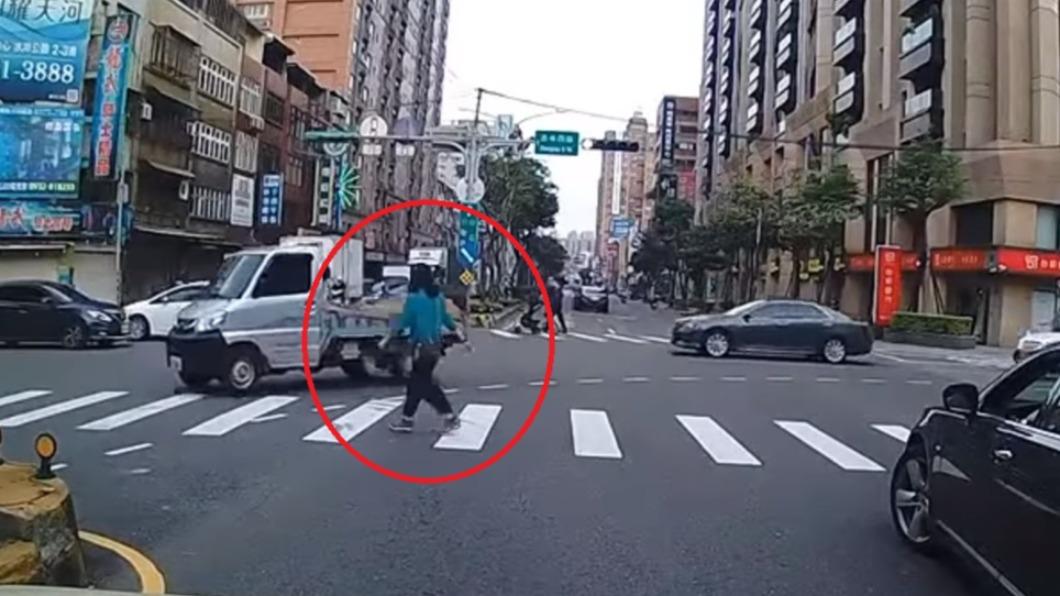 女子過馬路時多次回頭確認後方轉彎來車。（圖／翻攝自爆廢公社二館）