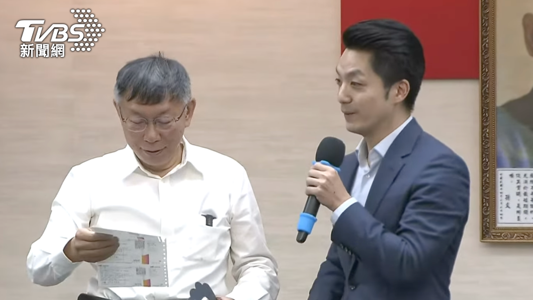 蔣萬安送上音樂會票券,柯文哲一臉有興趣的樣子拿起來端詳。(圖/TVBS)