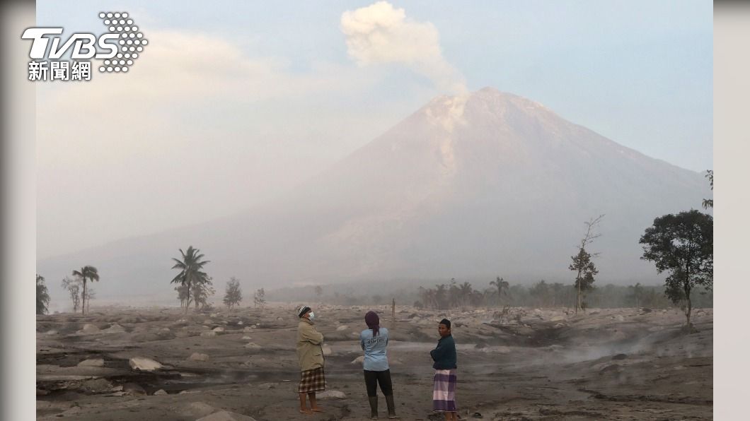 居民從遠方觀看噴發的塞梅魯火山,天空因為火山灰等而變得霧矇矇。(圖/達志影像美聯)