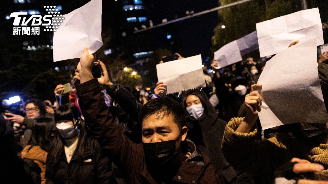 中國大陸民眾舉起白紙抗議。新疆烏魯木齊大火因當局嚴格封控而無法及時救災,造成10人死亡,引發民眾對於防疫政策的不滿,全國各地爆發「白紙革命」。(圖/達志影像路透)