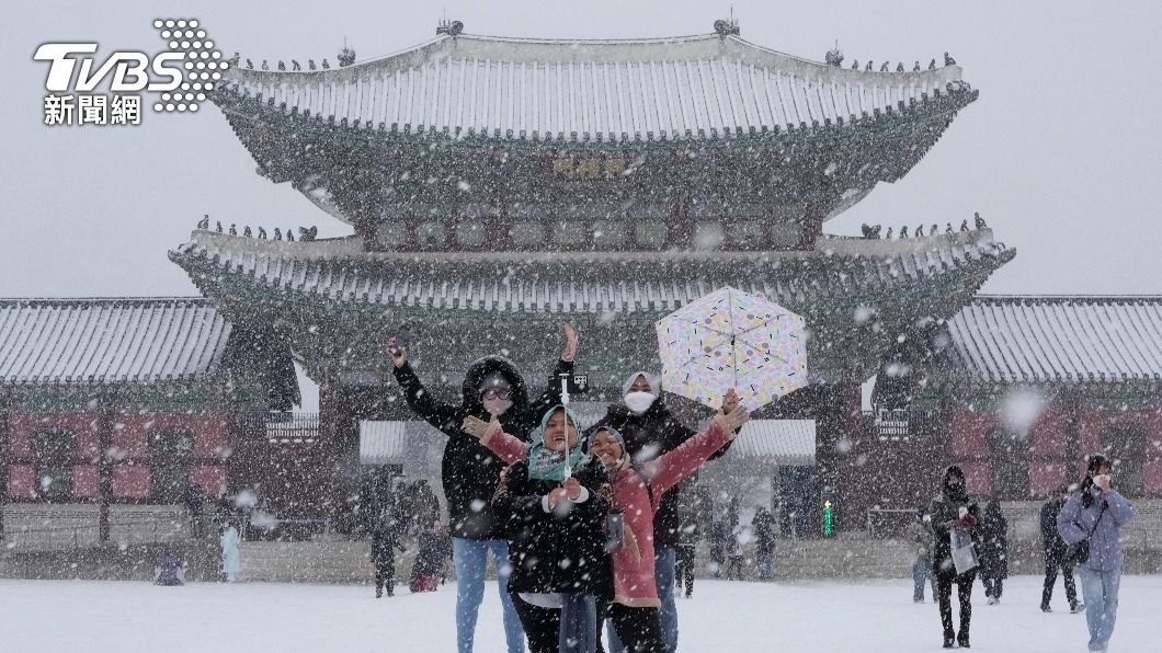 南韓首爾景福宮前,民眾在大雪中合影留念。(圖/達志影像美聯社)