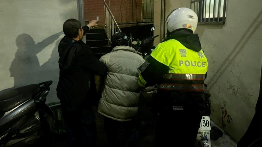 何姓男子坐在地上全身淋濕 等待警方救援 (圖/基隆市警方提供)