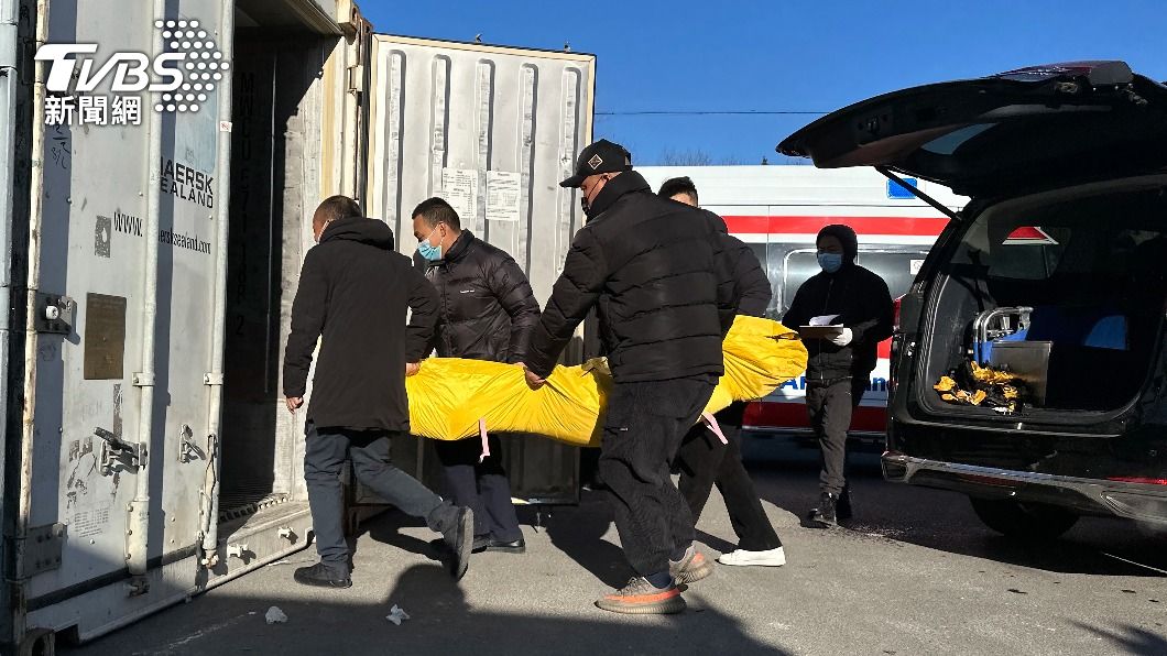 中國葬儀社人員將死者大體存放到臨時貨櫃。(圖/達志影像美聯社)