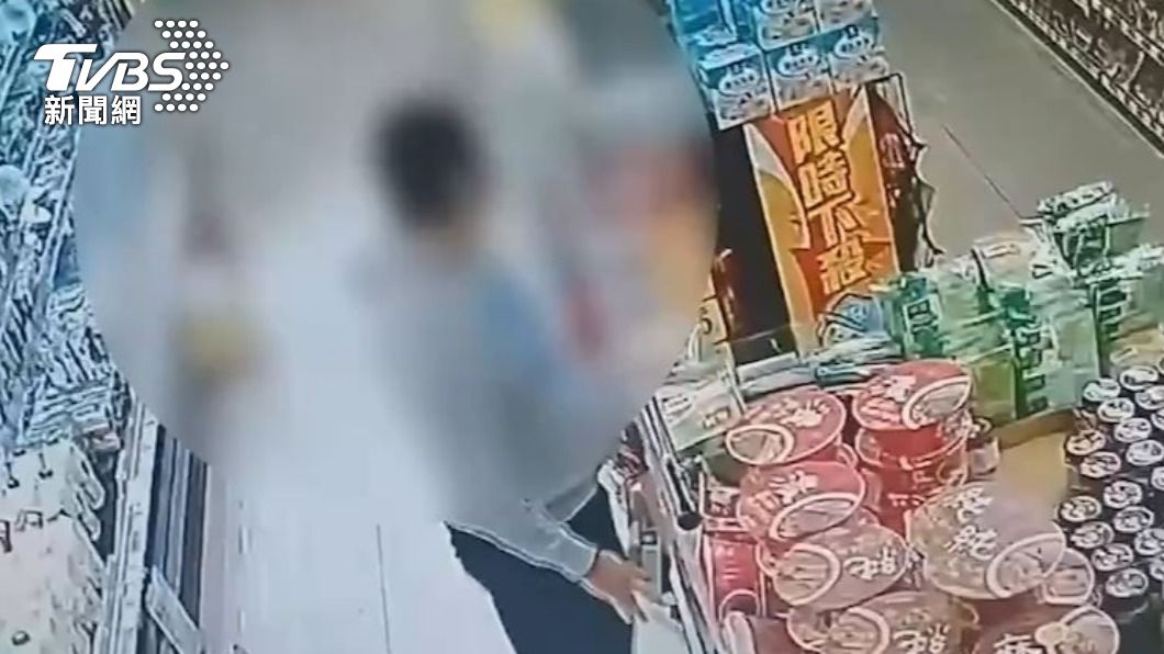 趁著超市店員不注意時將偷來的酒藏進包包內。(圖/TVBS)