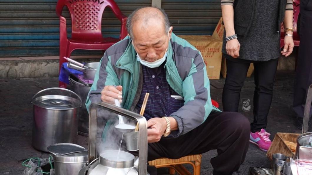 大家如圍爐般坐南門圓環路邊，以鋼杯喝杏仁茶配油條。（圖／金大佛的奪門而出家日誌提供）