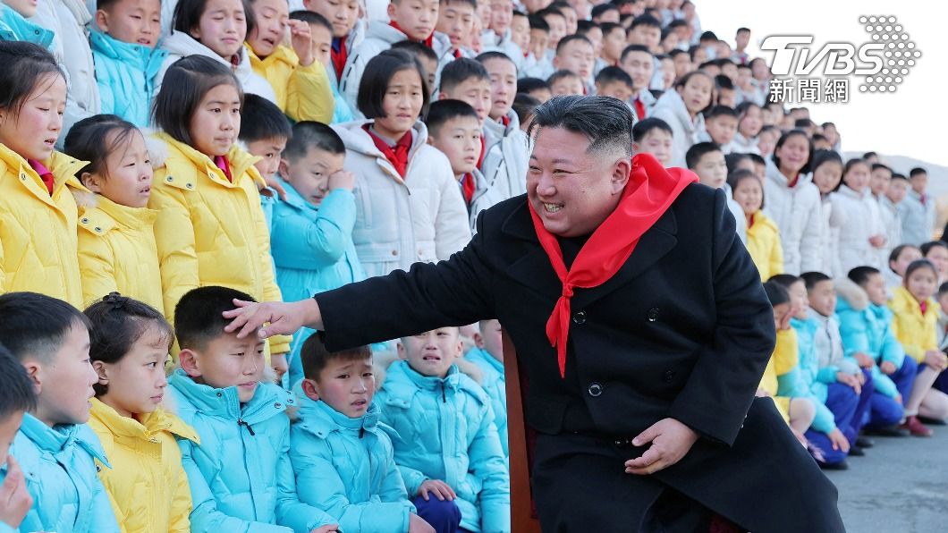 金正恩開心摸著孩童的頭,但孩童神情略顯尷尬。(圖/達志影像路透社)