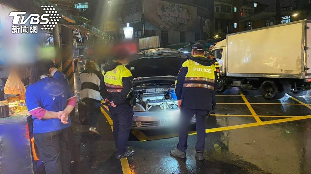 警員將車輛推到安全處後，化身黑手幫忙民眾修車。（圖／TVBS）