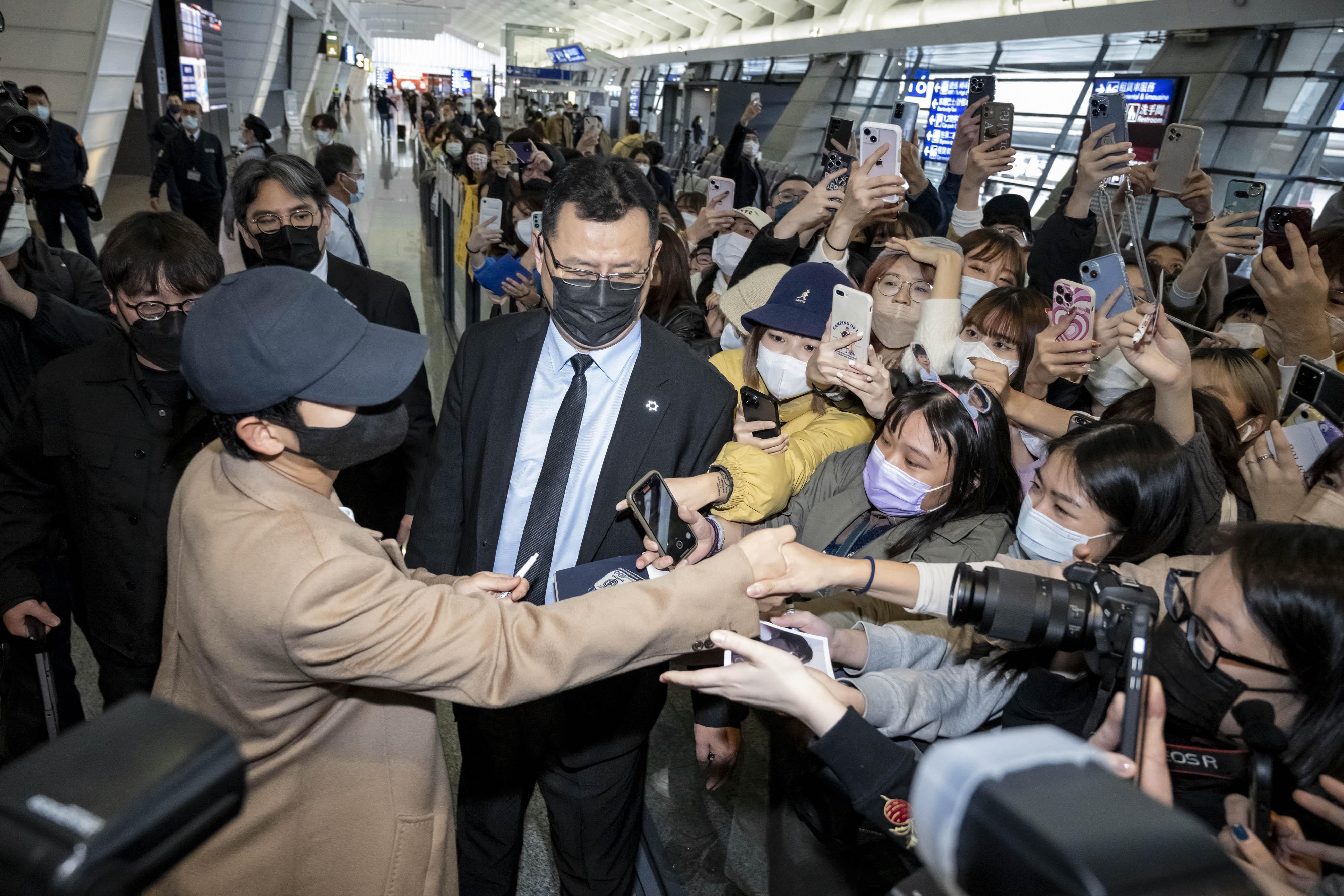 丁海寅與在機場守候的粉絲親切問好、握手。(圖/LV、FNC娛樂提供)