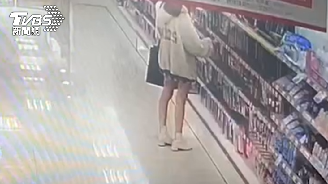 女子將商品從包裝盒內拿出來放進自己的包包裡。(圖/TVBS)